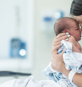 A mother with her newborn baby after childbirth with a midwife and doula.