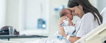 A mother with her newborn baby after childbirth with a midwife and doula.