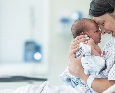 A mother with her newborn baby after childbirth with a midwife and doula.