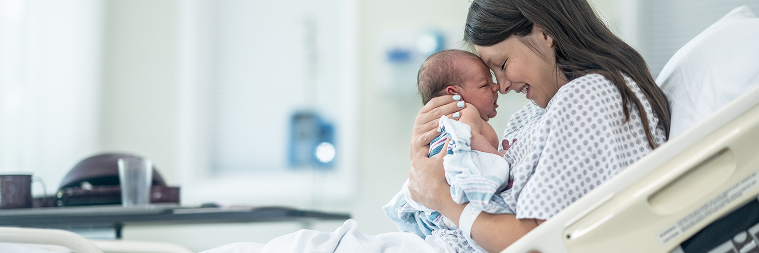 A mother with her newborn baby after childbirth with a midwife and doula.