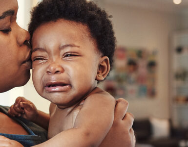 A mother holding her crying baby, who is showing signs of concussion.