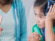 A girl in the emergency room, seeing a doctor for care after hurting herself at a soccer game.