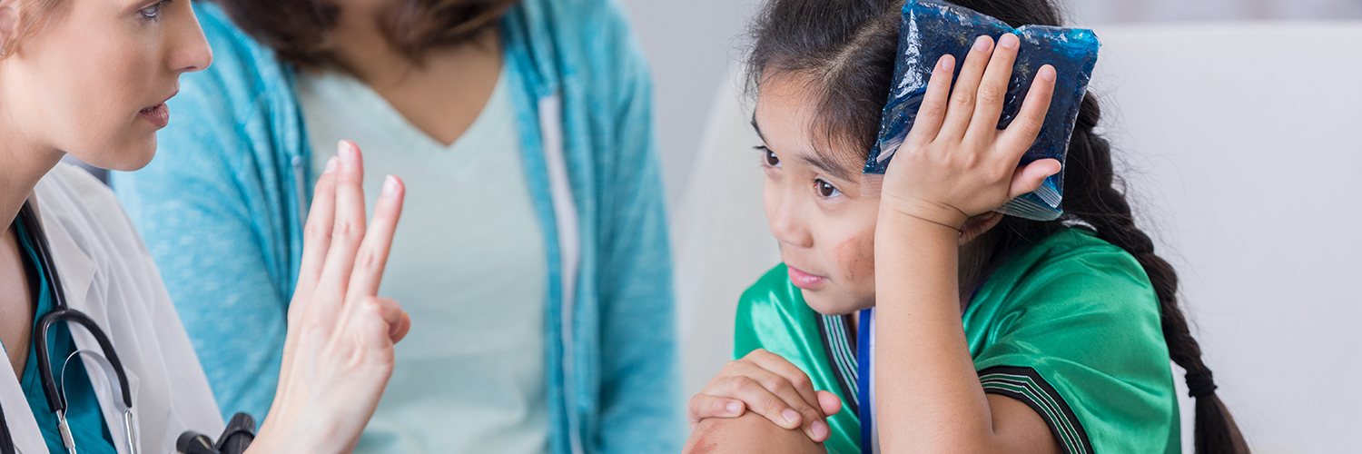 A girl in the emergency room, seeing a doctor for care after hurting herself at a soccer game.