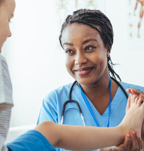 A doctor working with her young CRMO (Chronic Recurrent Multifocal Osteomyelitis) patient.