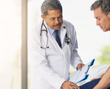 A doctor treating his patient's knee pain with interventional pain management techniques.