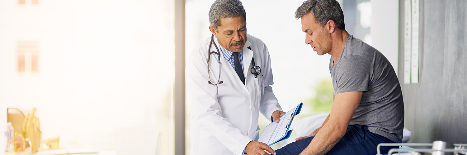 A doctor treating his patient's knee pain with interventional pain management techniques.