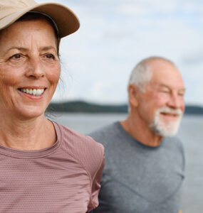 An older woman and man getting exercise on the beach.