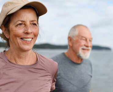 An older woman and man getting exercise on the beach.