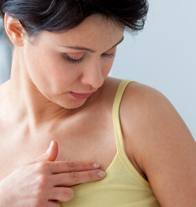 A woman speaking to her doctor about breast lumps as part of her breast cancer screening.