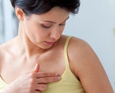 A woman speaking to her doctor about breast lumps as part of her breast cancer screening.