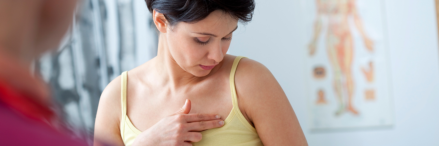 A woman speaking to her doctor about breast lumps as part of her breast cancer screening.