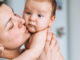 A mother holding her baby, who may need tongue tie surgery due to feeding issues.