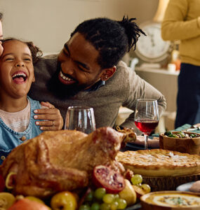 A family gathered at the dining room table celebrating the holidays together.