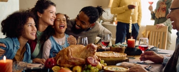 A family gathered at the dining room table celebrating the holidays together.