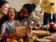 A family gathered at the dining room table celebrating the holidays together.