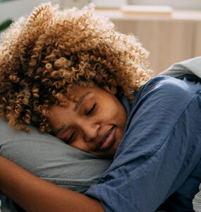 A woman deep sleeping peacefully in her bed.