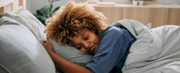 A woman deep sleeping peacefully in her bed.