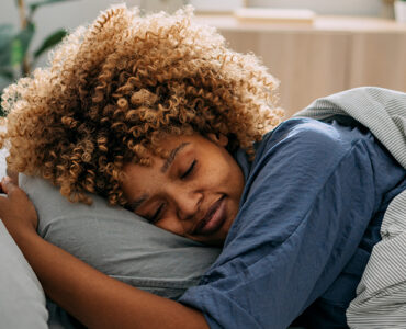 A woman deep sleeping peacefully in her bed.
