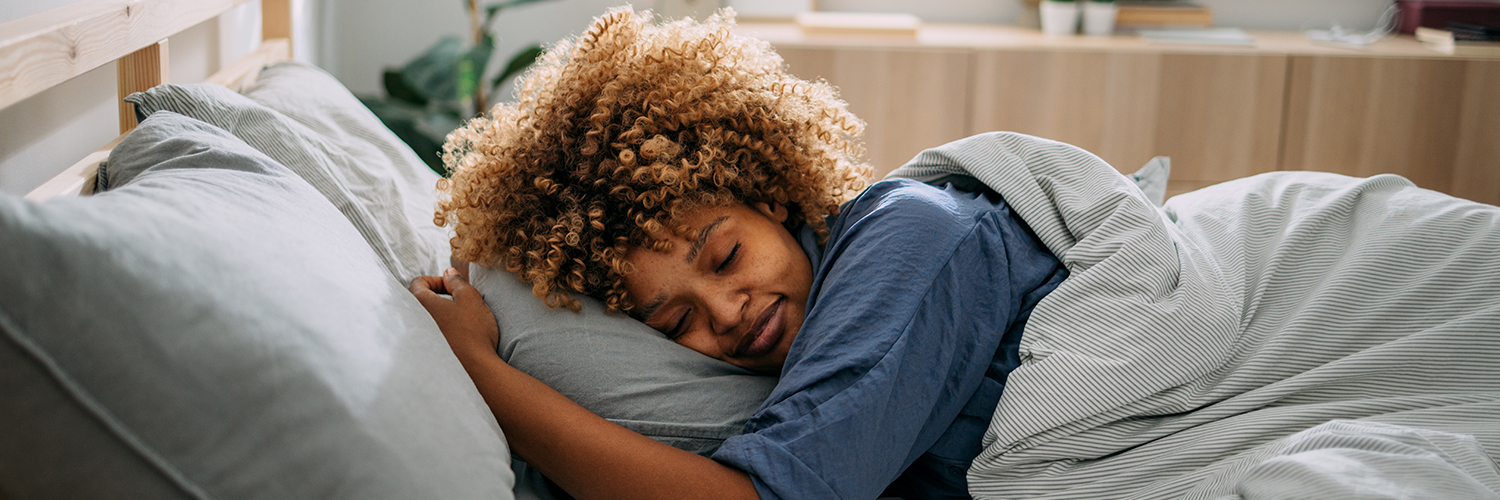 A woman deep sleeping peacefully in her bed.