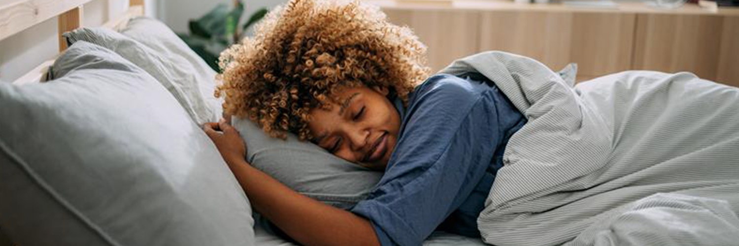 A woman deep sleeping peacefully in her bed.