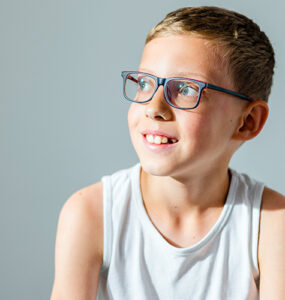 A boy sitting in a doctor's office, being evaluated for a Tourette Syndrome diagnosis.