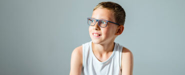 A boy sitting in a doctor's office, being evaluated for a Tourette Syndrome diagnosis.