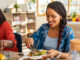 Two women sitting at the table together, eating healthy whole and plant-based foods.