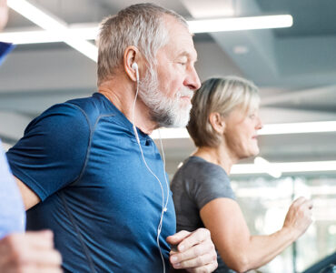 A group of older adults exercising on treadmills next to one another, as part of their cardiac rehab program.