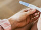 The hands of a woman looking at a negative result on her pregnant result.