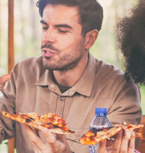 A family having pizza together at the dining room table, laughing and enjoying time spent together.