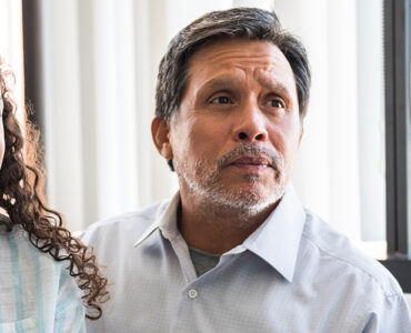 A father and daughter sitting at the doctor's office, discussing Tourette Syndrome.