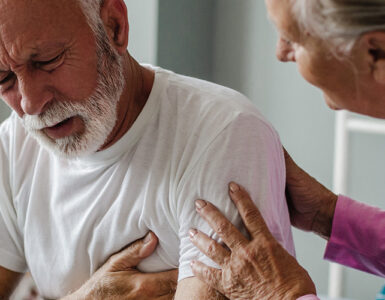 A man experiencing chest pain and shortness of breath, with his wife concerned about him.