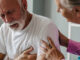 A man experiencing chest pain and shortness of breath, with his wife concerned about him.