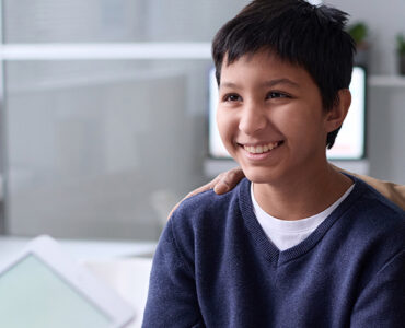 A boy at the doctor's office with his father, smiling.