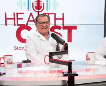 Three physicians from Stony Brook Medicine sitting in the podcast studio to discuss a mission trip.