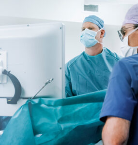 Two surgeons in the operating room, conducting robotic knee replacement surgery.