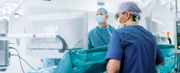 Two surgeons in the operating room, conducting robotic knee replacement surgery.