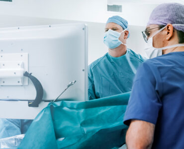 Two surgeons in the operating room, conducting robotic knee replacement surgery.
