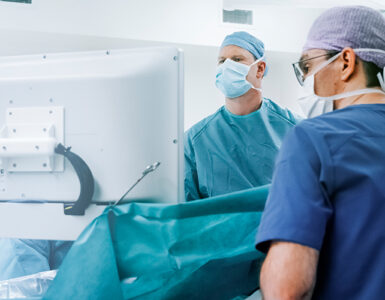 Two surgeons in the operating room, conducting robotic knee replacement surgery.