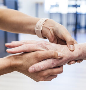 An older woman having her hand and wrist examined by an orthopedist because of pain.