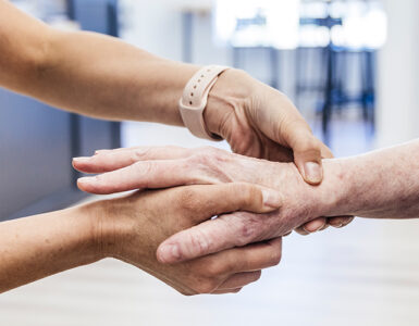 An older woman having her hand and wrist examined by an orthopedist because of pain.
