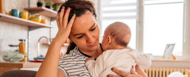 woman holding baby at kitchen table