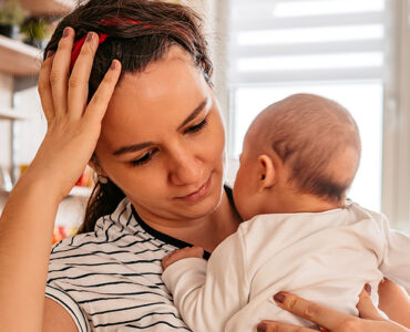 woman holding baby at kitchen table