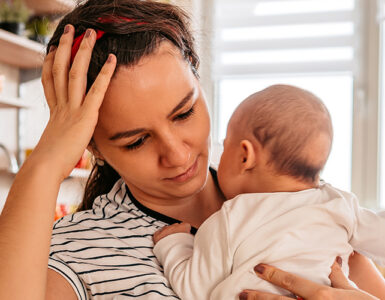woman holding baby at kitchen table