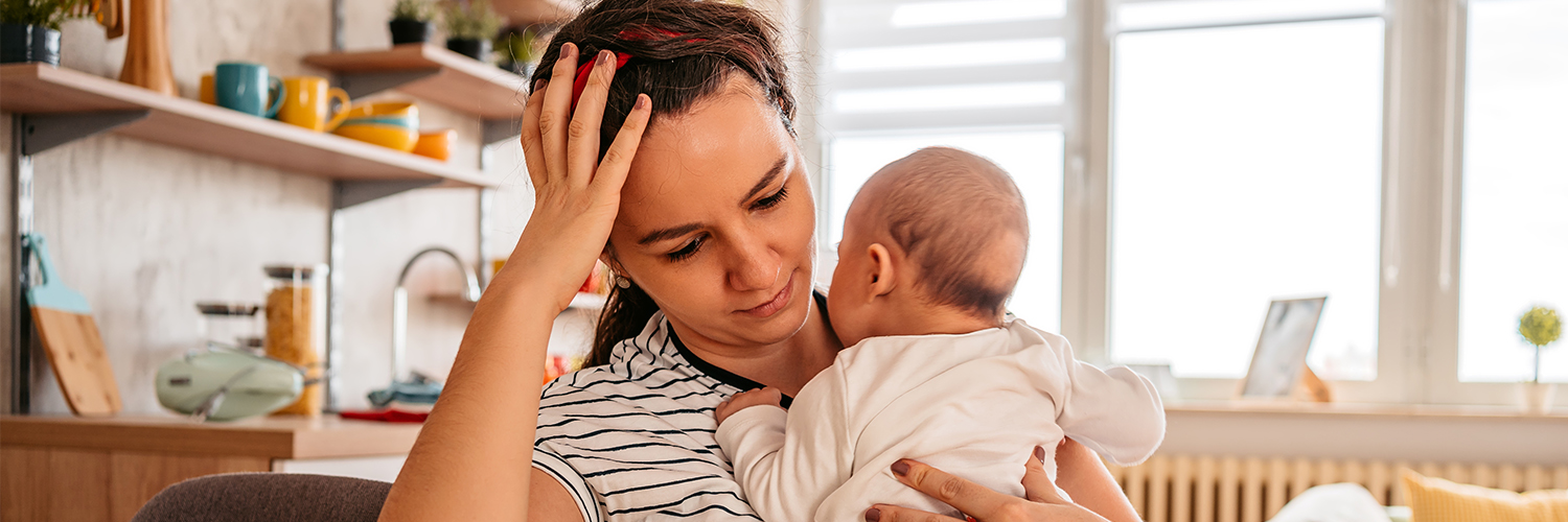 woman holding baby at kitchen table