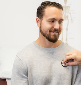 A young male patient sitting with his doctor in a medical office.