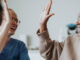 A black middle-aged woman giving her oncologist a high five while smiling.