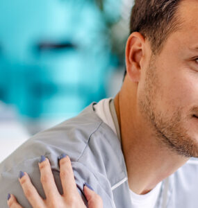 A young man sitting in a doctor's office, being consoled by the nurse.