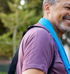 A middle-aged man and woman standing together outdoors after a workout.
