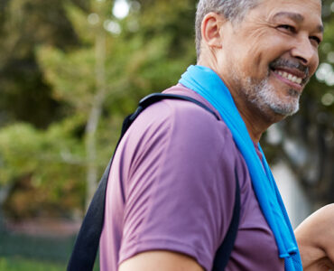 A middle-aged man and woman standing together outdoors after a workout.